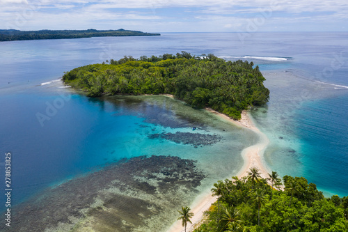 A coral reef surrounds idyllic islands off the coast of New Britain in Papua New Guinea. This area is part of the Coral Triangle due to its high marine biodiversity. photo