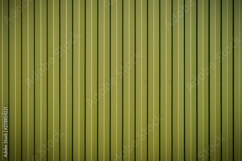 Yellow-green fence from a professional sheet. New metal fence. Background or texture