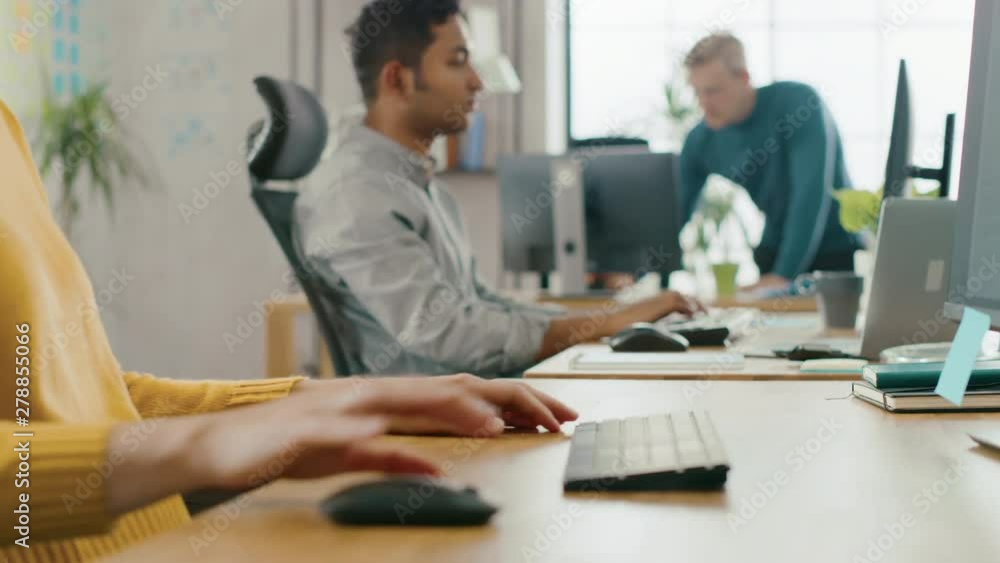 Handsome IT Specialist Sitting at His Desk works on a Laptop, Has Discussion with Indian Project Manager. Diverse Team of Young Professionals Working in Office Handsome IT Specialist Sitting at His Desk works on a Laptop, Has Discussion with Indian Project Manager. Diverse Team of Young Professionals Working in Office