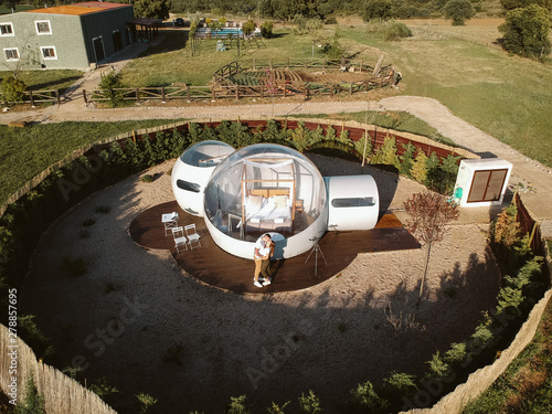 aerial view of a Young couple kissing by unusual bubble hotel