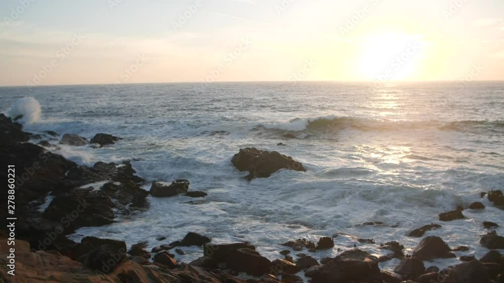 Waves crashing on rocky cliffs during beautiful sunset Waves crashing on rocky cliffs during beautiful sunset