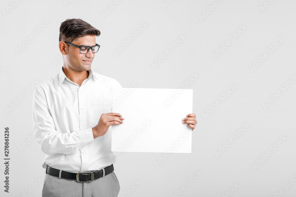 Young Indian business executive showing blank sign board over white background Young Indian business executive showing blank sign board over white background