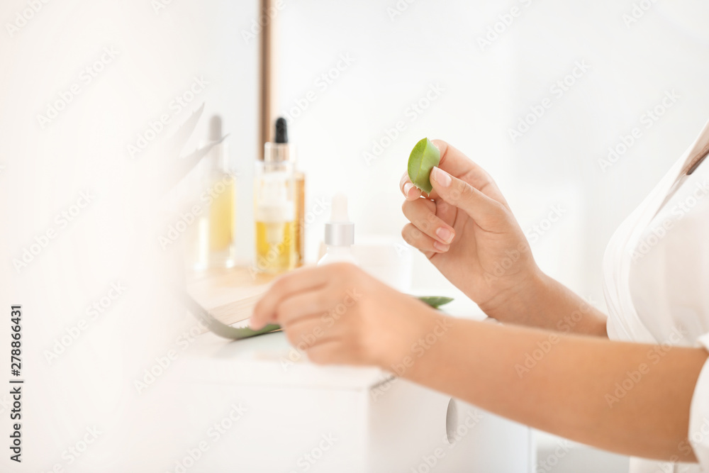 Fototapeta premium Beautiful young woman using aloe vera at home, closeup