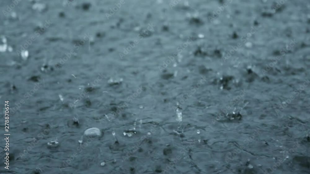 Rain drops fall on water surface of pond, lake or river forming a uniform background. bad weather concept Rain drops fall on water surface of pond, lake or river forming a uniform background. bad weather concept