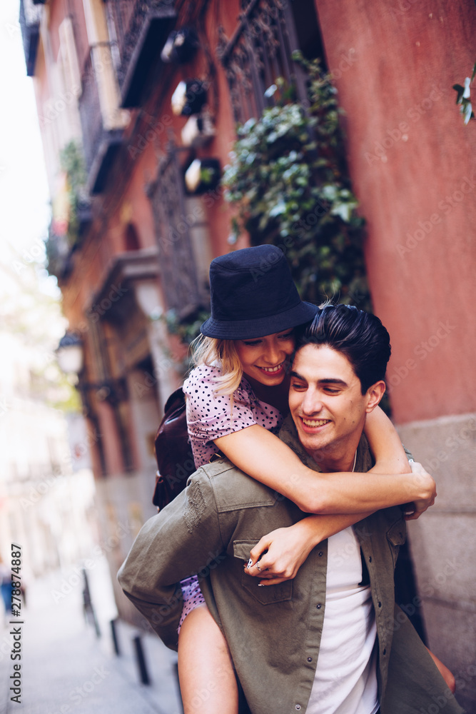 Man giving piggyback ride to his girlfriend outdoors Man giving piggyback ride to his girlfriend outdoors