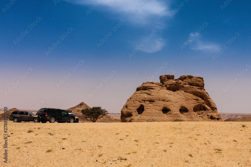 The sport utilities vehicles near the Cathedral Stone, an isolated natural sandstone formation and popular tourist attraction in the desert near Riyadh