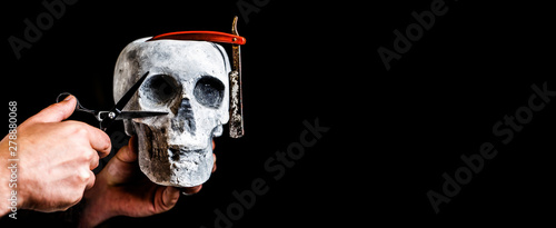 Skull barber. Vintage barber shop tools. Barber scissors and straight razor, barber shop. Still life skull with shaving tools. Barber shop tool on black background with copy space. Copy space photo