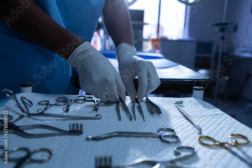 Surgeon arranging surgical instrument in operating room of hospital