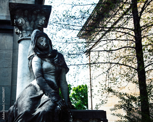 Tombstones in cemetery at dusk, gothic style crosses Paris