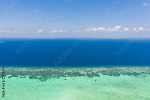 Atoll and blue sea  view from above. Seascape by day. Turquoise and blue sea water.