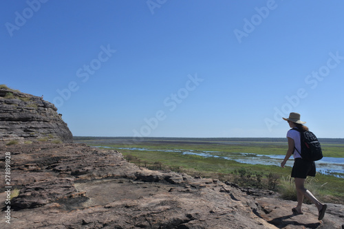 Woman tourist hiking at Ubirr rock art site in Kakadu National Park Northern Territory of Australia