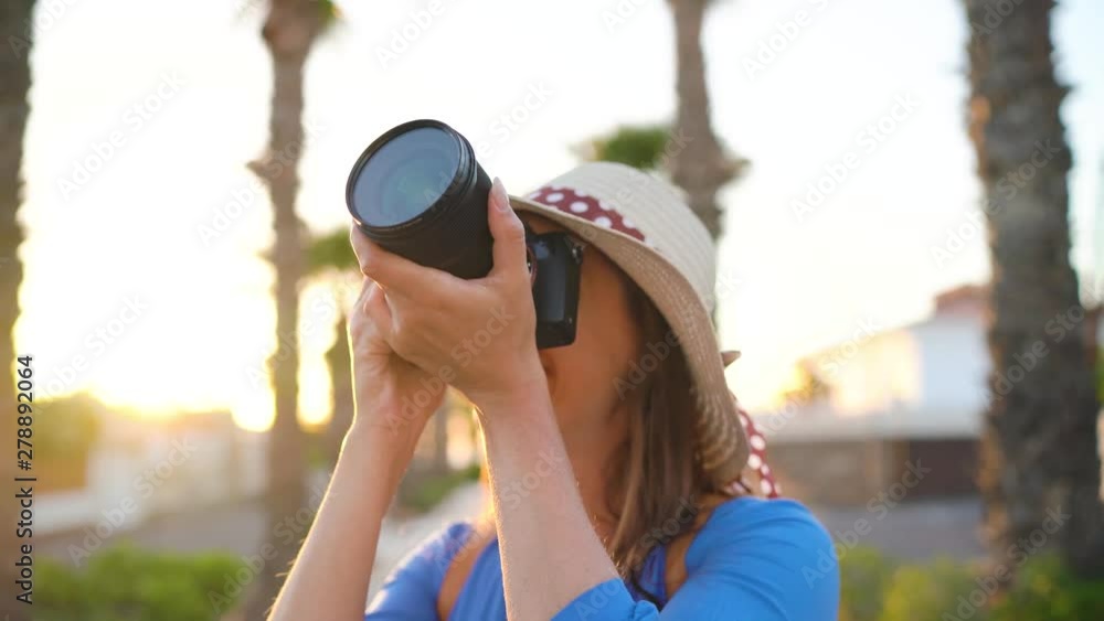 Photographer tourist woman taking photos with camera in a beautiful tropical landscape at sunset Photographer tourist woman taking photos with camera in a beautiful tropical landscape at sunset