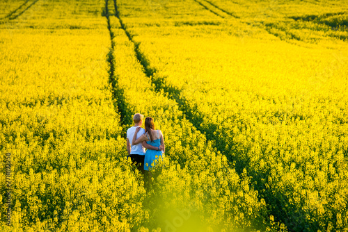Romantic date in the spring nature. Yellow colza field standing together in beautiful yellow nature