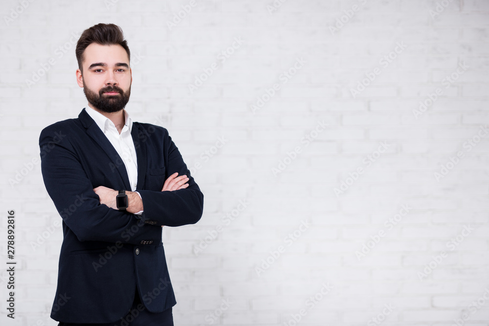 portrait of young bearded businessman over white brick wall background portrait of young bearded businessman over white brick wall background