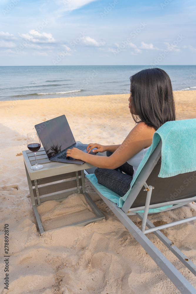 Woman freelance working on laptop in summer vacation