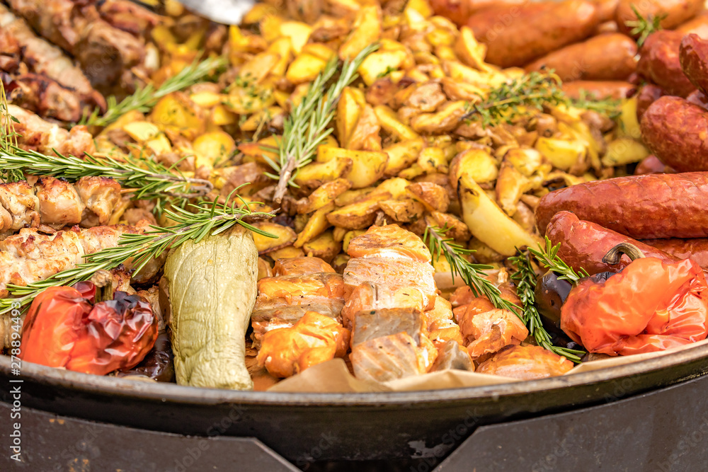 Fried potatoes with fried sausages in a pan. Dish fried potatoes with sausages, onions, garlic, cumin, pepper and seasonings. Fried potatoes with fried sausages in a pan. Dish fried potatoes with sausages, onions, garlic, cumin, pepper and seasonings.