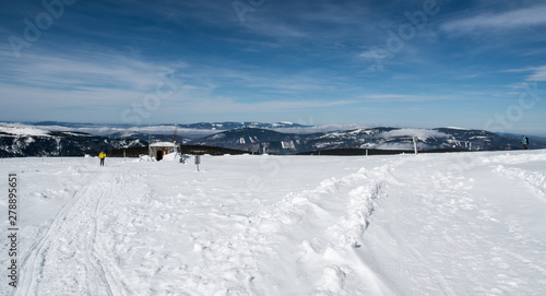 Fototapeta Naklejka Na Ścianę i Meble -  winter mountain panorama with many hills, few hikers and blue sky with clouds from Praded hill in Jeseniky mountains in Czech republic