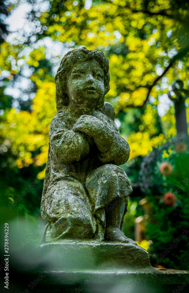 Marble statue and an ancient abandoned Gothic cemetery