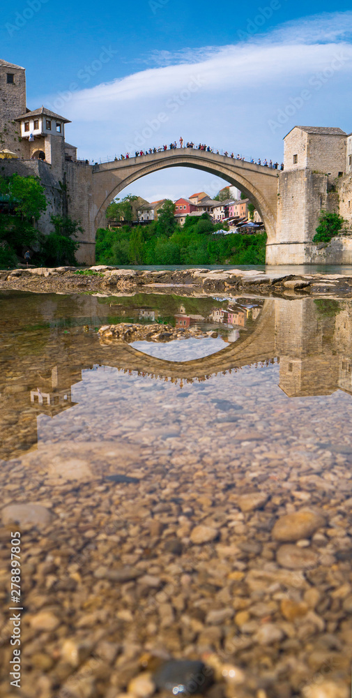 Stari Most bridge and its reflection in river Neretva - Old town of Mostar, Bosnia and Herzegovina, April 2019