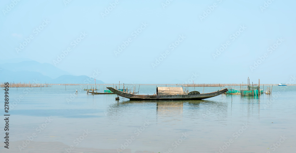 Lonely wooden fishing boat on the lagoon looking forward to going to the sea as a wish for people to look forward to good things in the vast sea