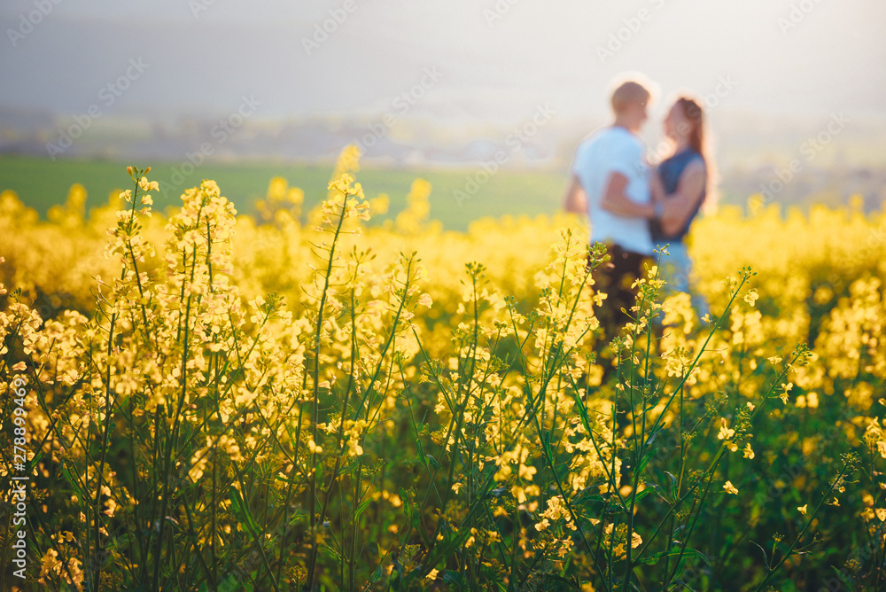 Young couple in love outdoor.Stunning sensual outdoor portrait of young stylish fashion couple posing in spring field