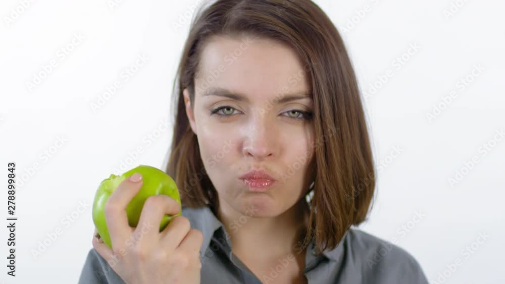 Close up portrait of attractive young woman enjoying delicious green apple on white background Close up portrait of attractive young woman enjoying delicious green apple on white background