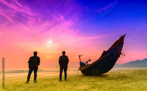 Vászonkép Silhouette man standing in front of the sea with sunrise sky in the morning as a