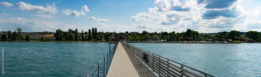panorama view of the long pier at Altnau harbor on Lake Constance with many boats and people