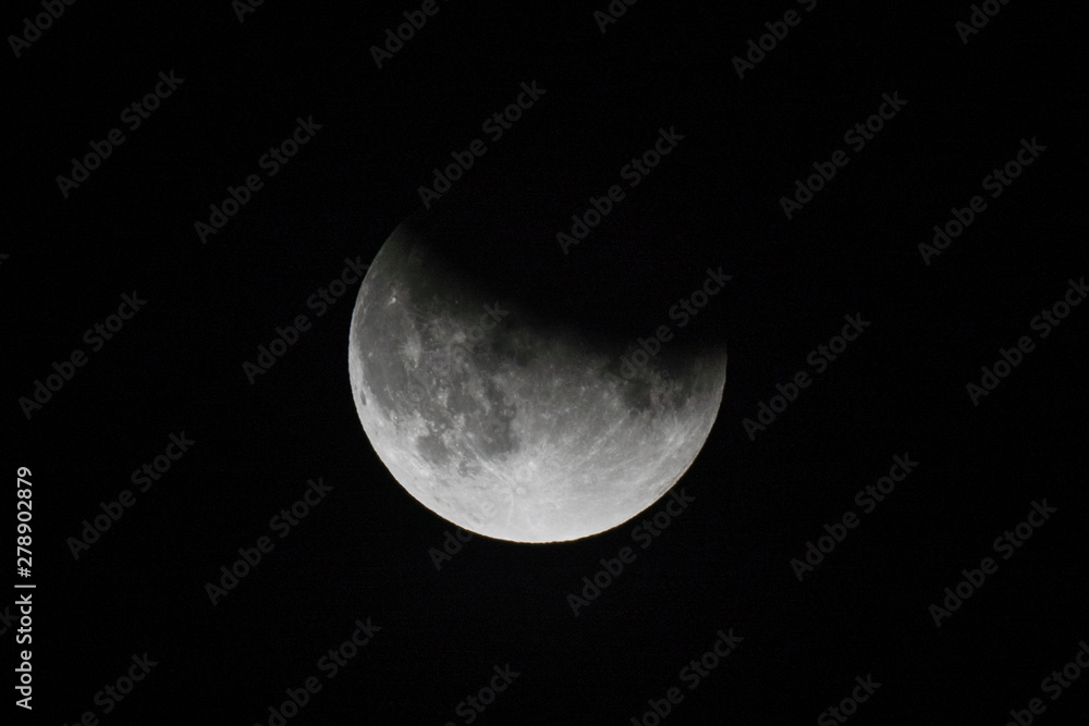 close up view of a partial lunar eclipse in the black night sky close up view of a partial lunar eclipse in the black night sky