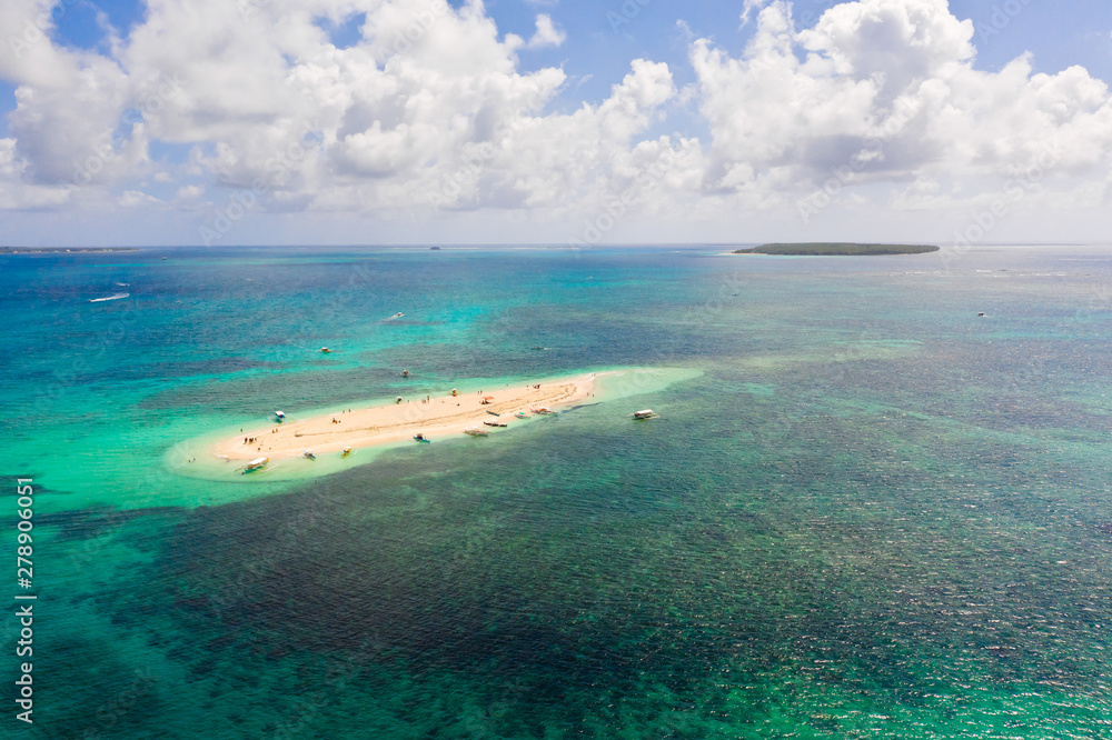 Naked Island, Siargao. The island of white sand on the atoll. Tourists relax on the white island. Seascape with sandy island.