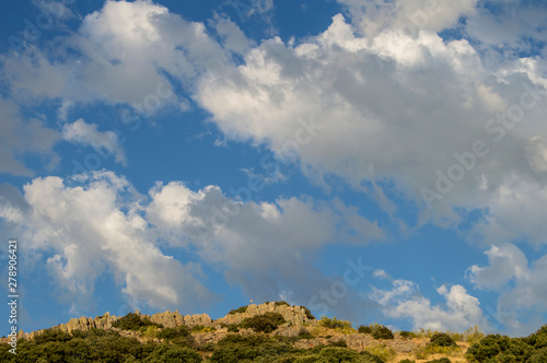 Fragment of rocky hill with sky and cottony clouds in a place of Spain.