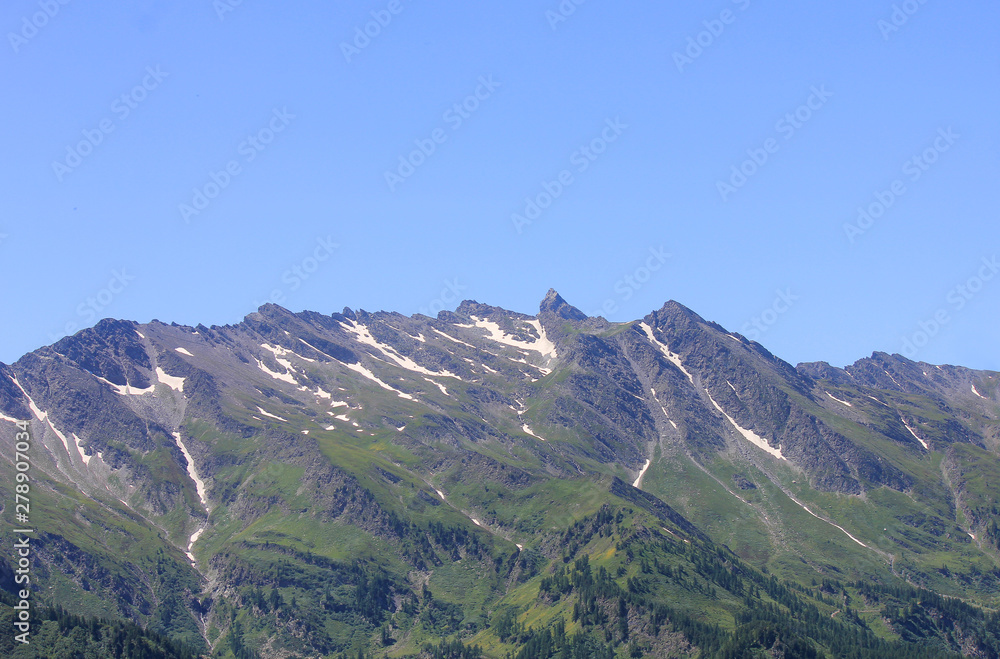 mountain range with glacier, vegetation and rocks