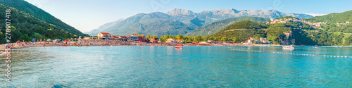 Summer seascape, Adriatic sea coastline with Jaz beach surrounded by mountains, Montenegro. Super wide panoramic view, people is a blurred