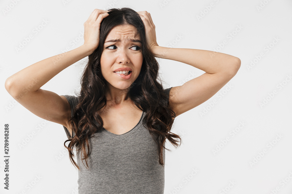 Beautiful confused displeased young woman posing isolated over white wall background. Beautiful confused displeased young woman posing isolated over white wall background.