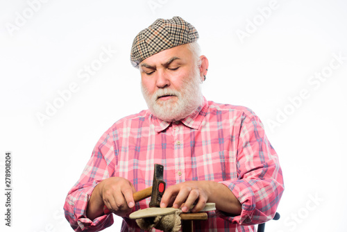 retro man repair shoes with hammer. Cobbler workmanship. mature shoemaker in workshop make shoes. shoemaker at work. shoemaker working with leather textile and hammer at workshop. perfectionist