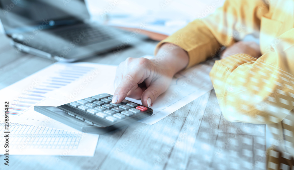 Fototapeta premium Hands of an accountant working on financial documents; light effect