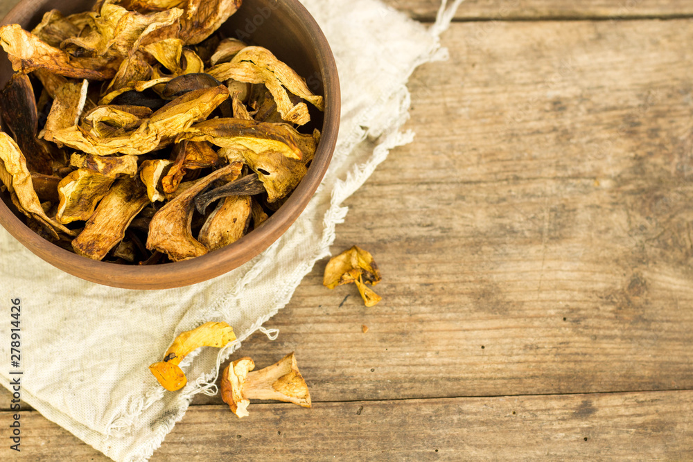 Dry mushroom chips in a bowl wooden background
