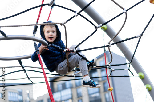 a little boy is having fun playing on the modern urban European playground