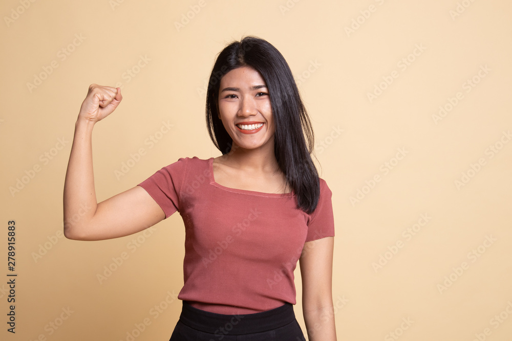 Obraz premium Beautiful young Asian woman flex bicep.