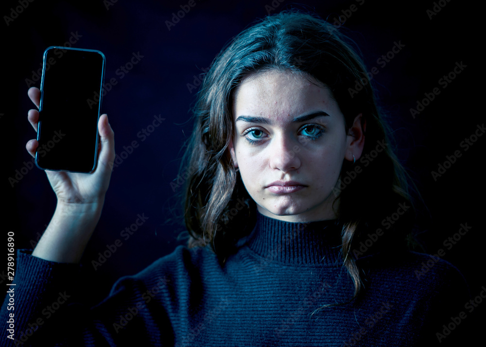 © SB Arts Media - Sad young girl with smartphone suffering harassment online. Onli