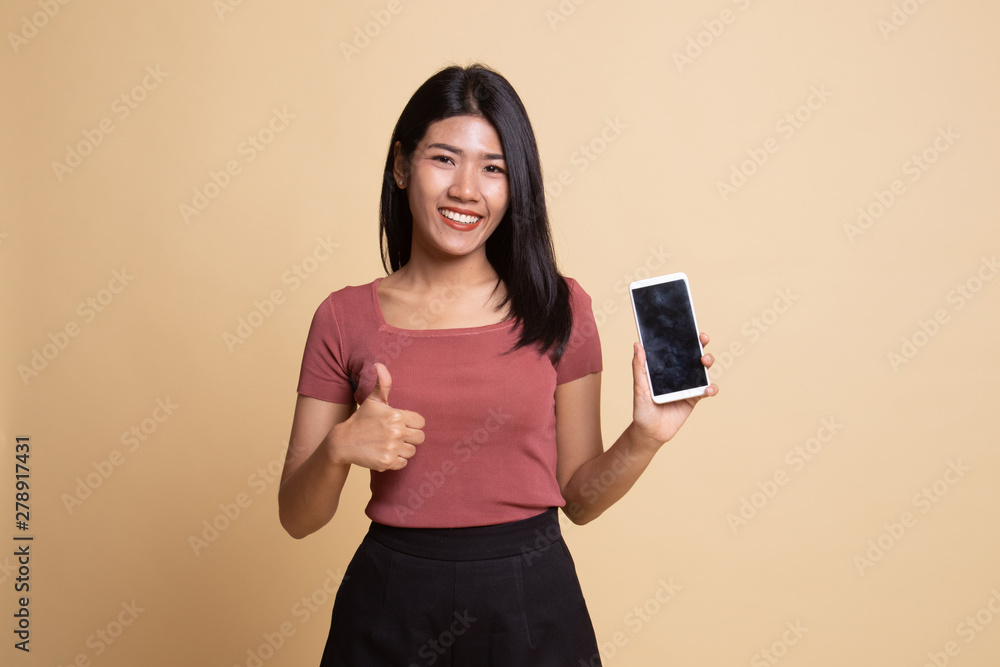 Young Asian woman show thumb up with mobile phone. Young Asian woman show thumb up with mobile phone.