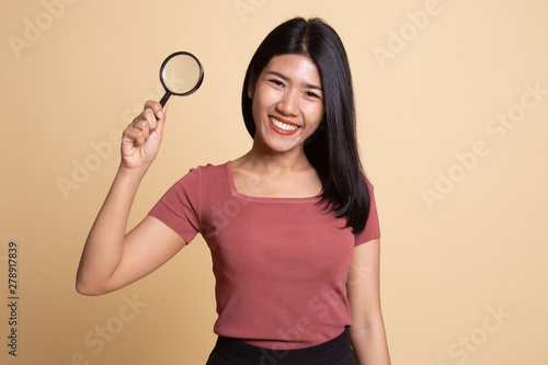 Young Asian woman with a magnifying glass. © halfbottle