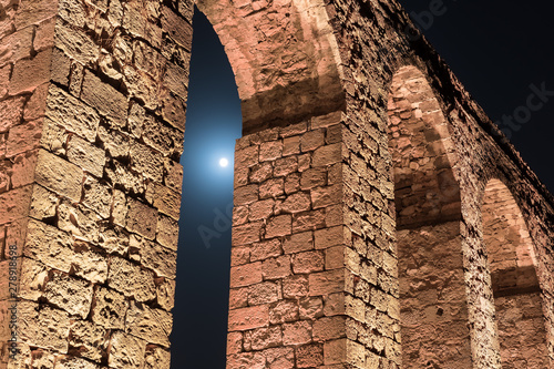 Fotografie, Tablou Night  view of the remains of an ancient Roman aqueduct located between Acre and