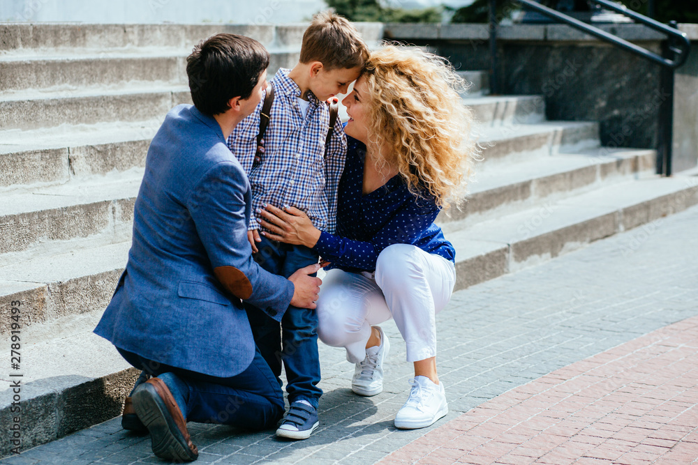 Pupil boy say good bye with father and near stairs of school. Sad emotions back to school concept. Pupil boy say good bye with father and near stairs of school. Sad emotions back to school concept.