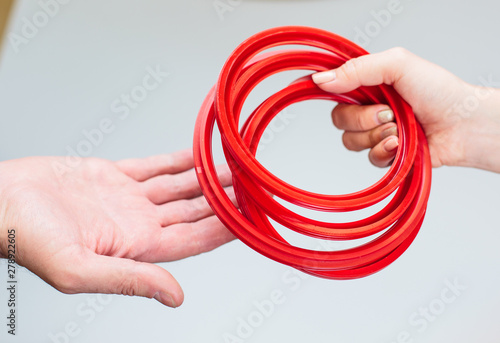 Oil seal for engines Industrial use. Hand holding pink elastic rubber band on white background. Hydraulic and pneumatic o-ring seals
