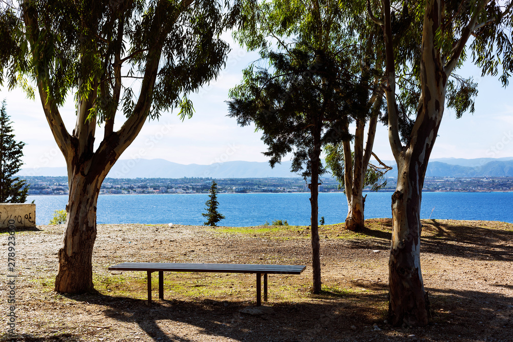 A resting place with a bench and overlooking the Corinthian Gulf and the town of Loutraki, Greece A resting place with a bench and overlooking the Corinthian Gulf and the town of Loutraki, Greece