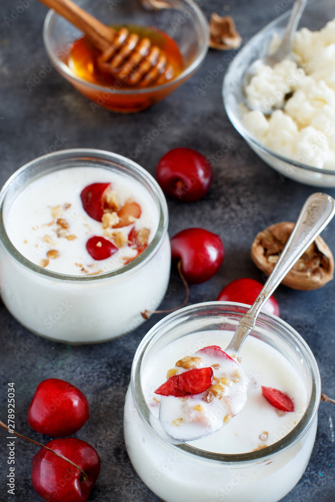 Fermented yogurt kefir in small bottles with cherries and walnuts Fermented yogurt kefir in small bottles with cherries and walnuts