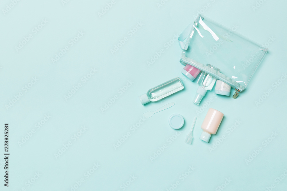 Top view of means for face care: bottles and jars of tonic, micellar cleansing water, cream, cotton pads on blue background. Bodycare concept with empty cpace for your ideas Top view of means for face care: bottles and jars of tonic, micellar cleansing water, cream, cotton pads on blue background. Bodycare concept with empty cpace for your ideas
