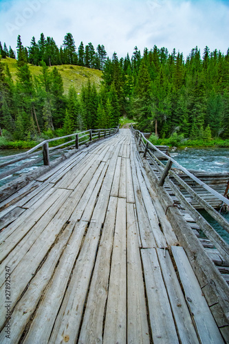 Wooden bridge across mountain stream. Altai Republic  Russia