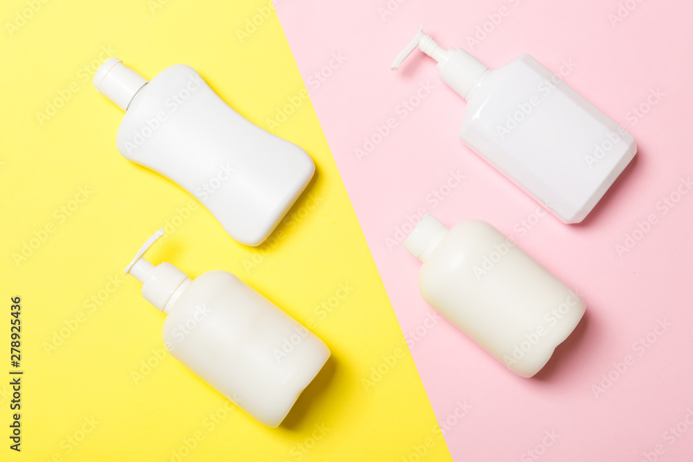 Set of White Cosmetic containers isolated on yellow background, top view with copy space. Group of plastic bodycare bottle containers with empty space for you design Set of White Cosmetic containers isolated on yellow background, top view with copy space. Group of plastic bodycare bottle containers with empty space for you design